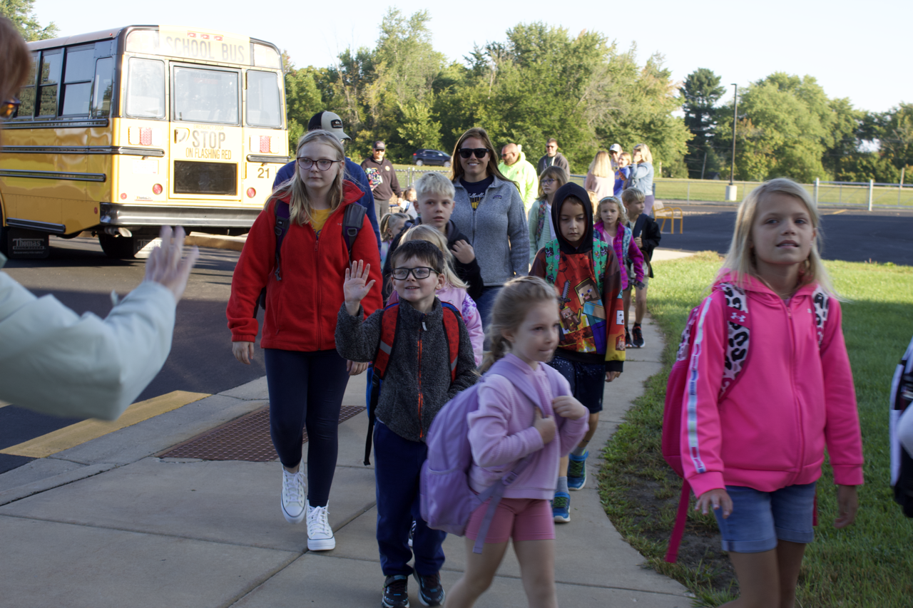 group of es students getting off the bus to come to school